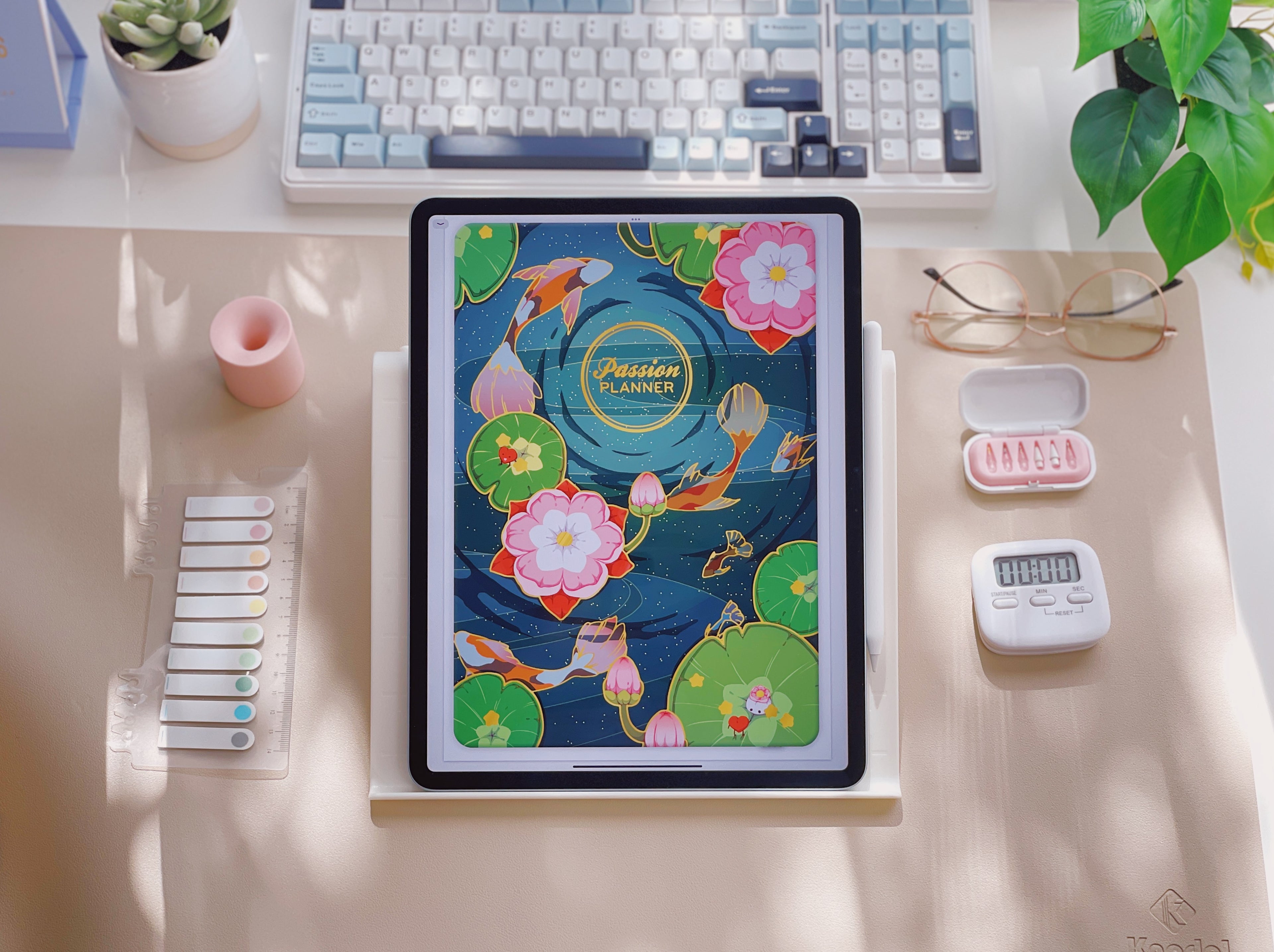 Tablet with a colorful case on a desk with a keyboard, plant, and other items.