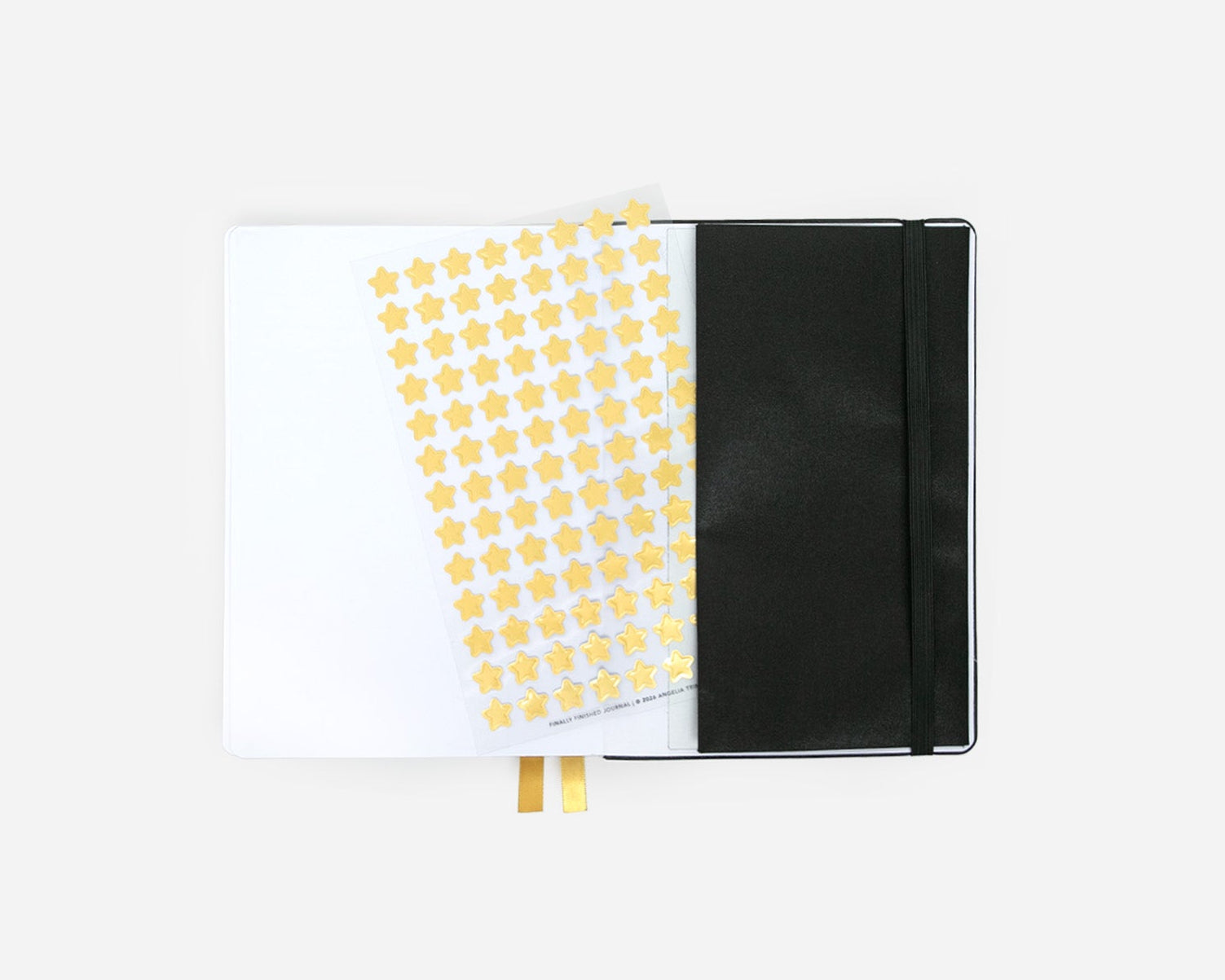 Journal with a black cover and yellow star stickers on a transparent sheet on a white background