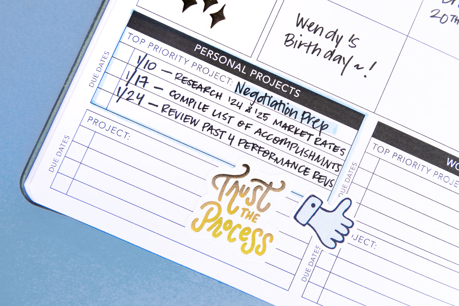 Close-up of a planner with text and a motivational quote on a blue background