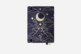 Notebook with celestial design featuring moon, stars, and mountains on a dark blue background.