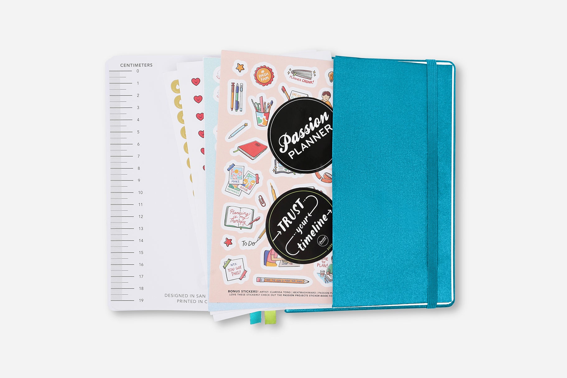 Turquoise planner with stickers and open pages on a white background