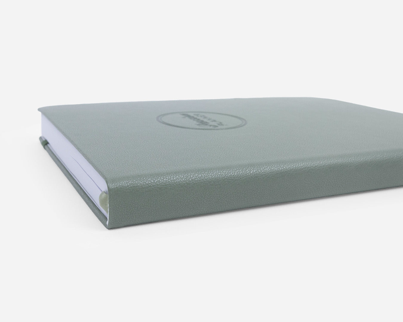 Green leather-bound planner close up on a white background