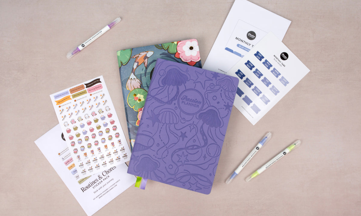 Purple mid-year planner with stationery items on a beige surface