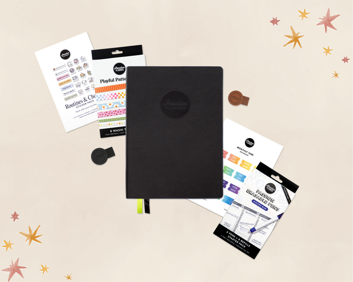 A black 2027 planner with a circular logo on the cover, shown with several stationery accessories and stickers around it on a light beige background with star illustrations. Visible branding includes 'Passion Planner'.