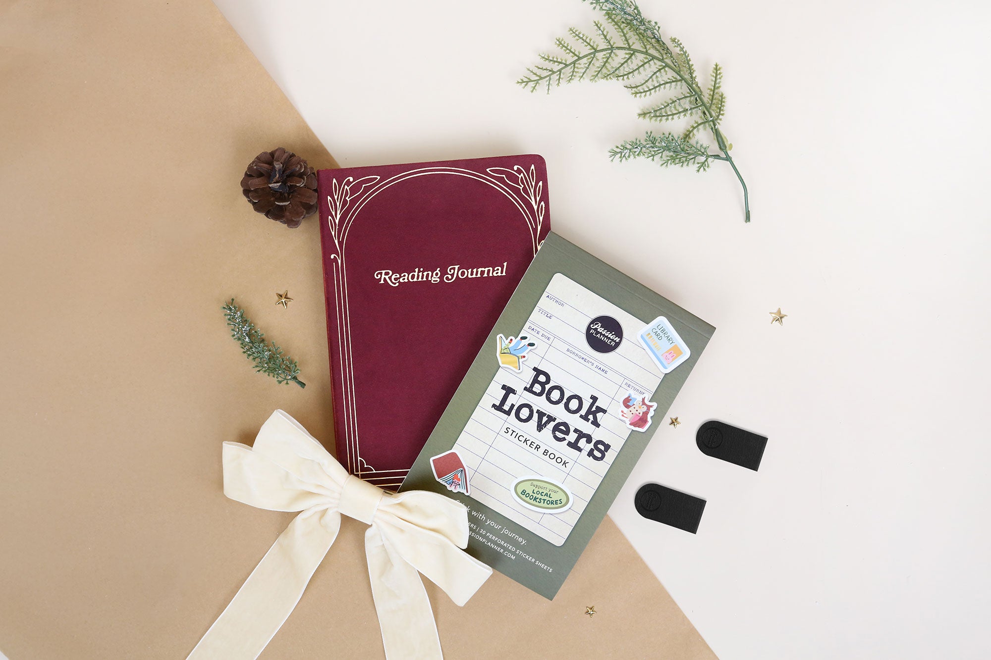 Red reading journal and 'Book Lovers' sticker book on a beige and white background