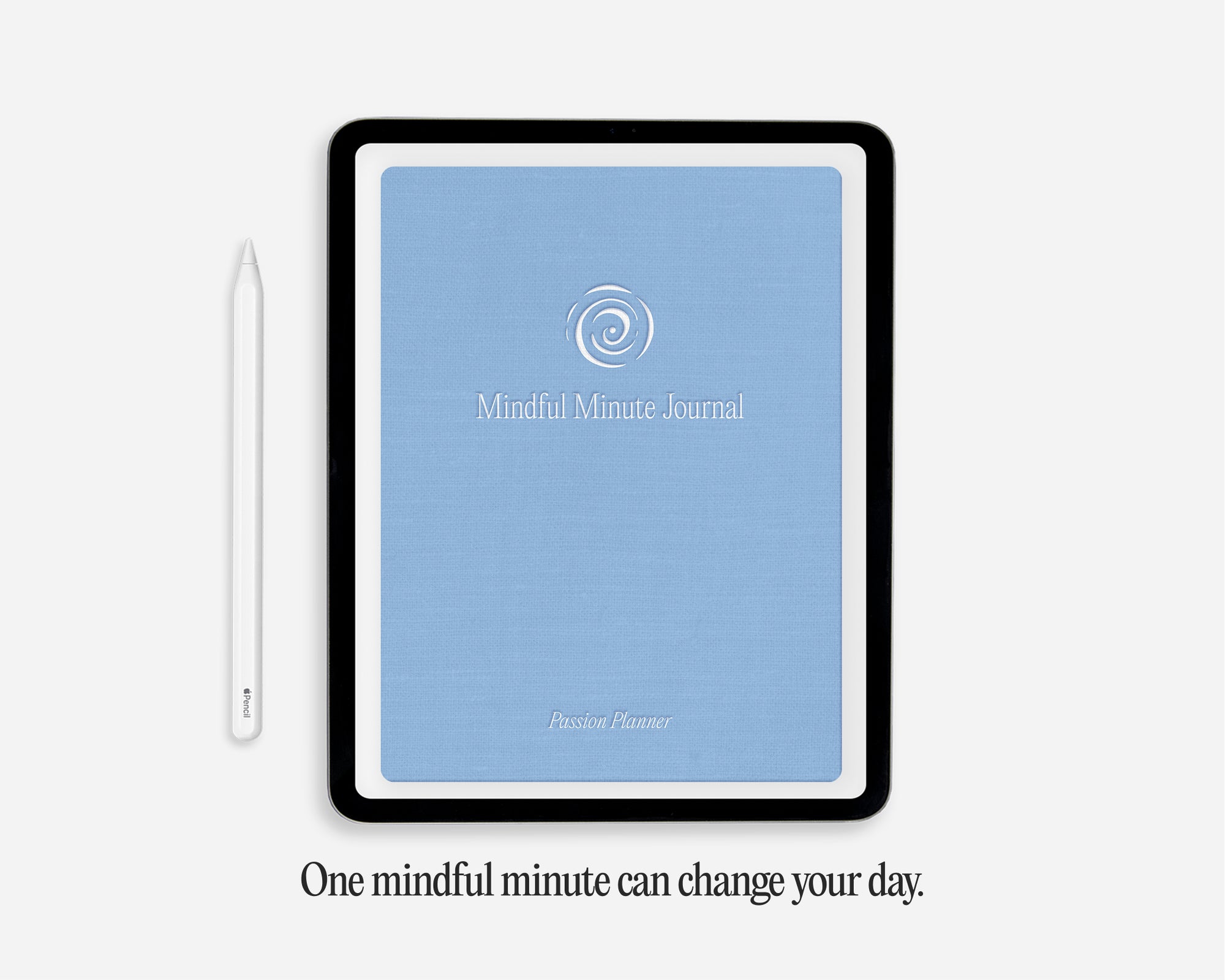 A tablet-style digital journal cover with a light blue front and black border, shown on a light gray background with a white stylus beside it and the text 'One mindful minute can change your day.' below.