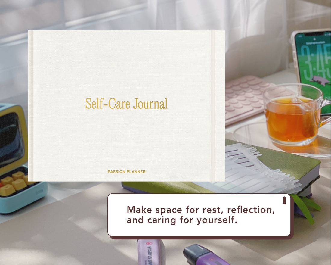 A white digital Self-Care Journal with gold lettering is shown in a styled desk setting with a glass of tea, a smartphone, and other office accessories. A text box at the bottom reads, &