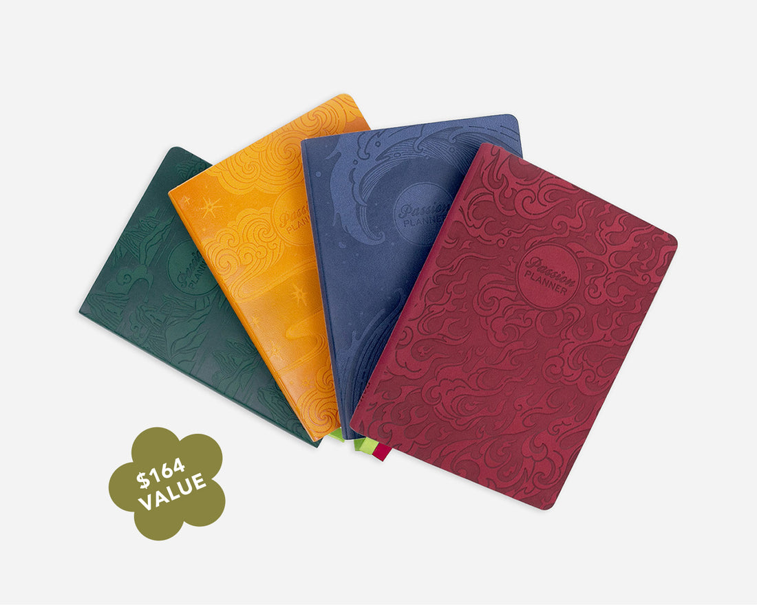 Four embossed planner covers in dark green, yellow, navy blue, and burgundy red, arranged in a fan shape on a light gray background with a &