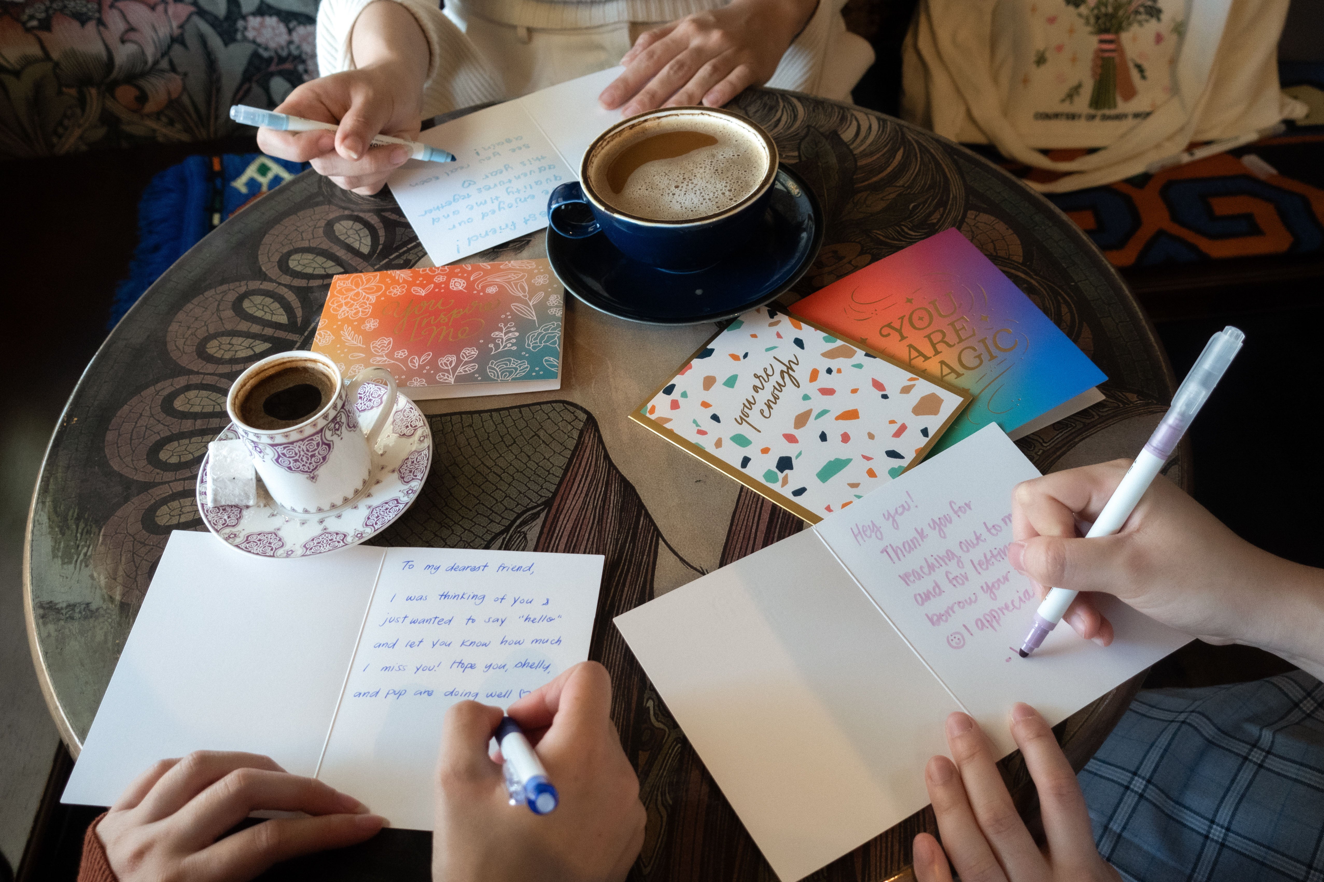 three people writing in greeting cards