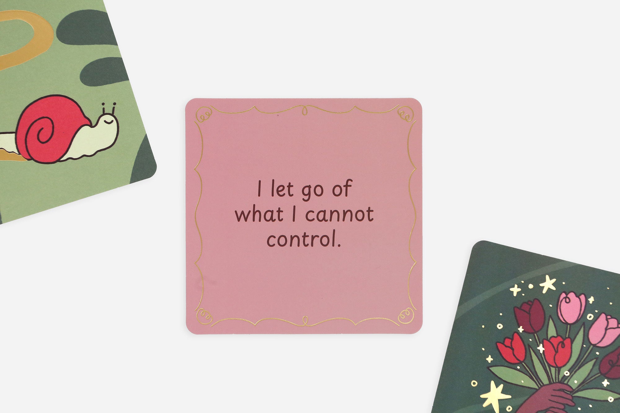 Pink affirmation card with motivational quote surrounded by other cards with designs and text.