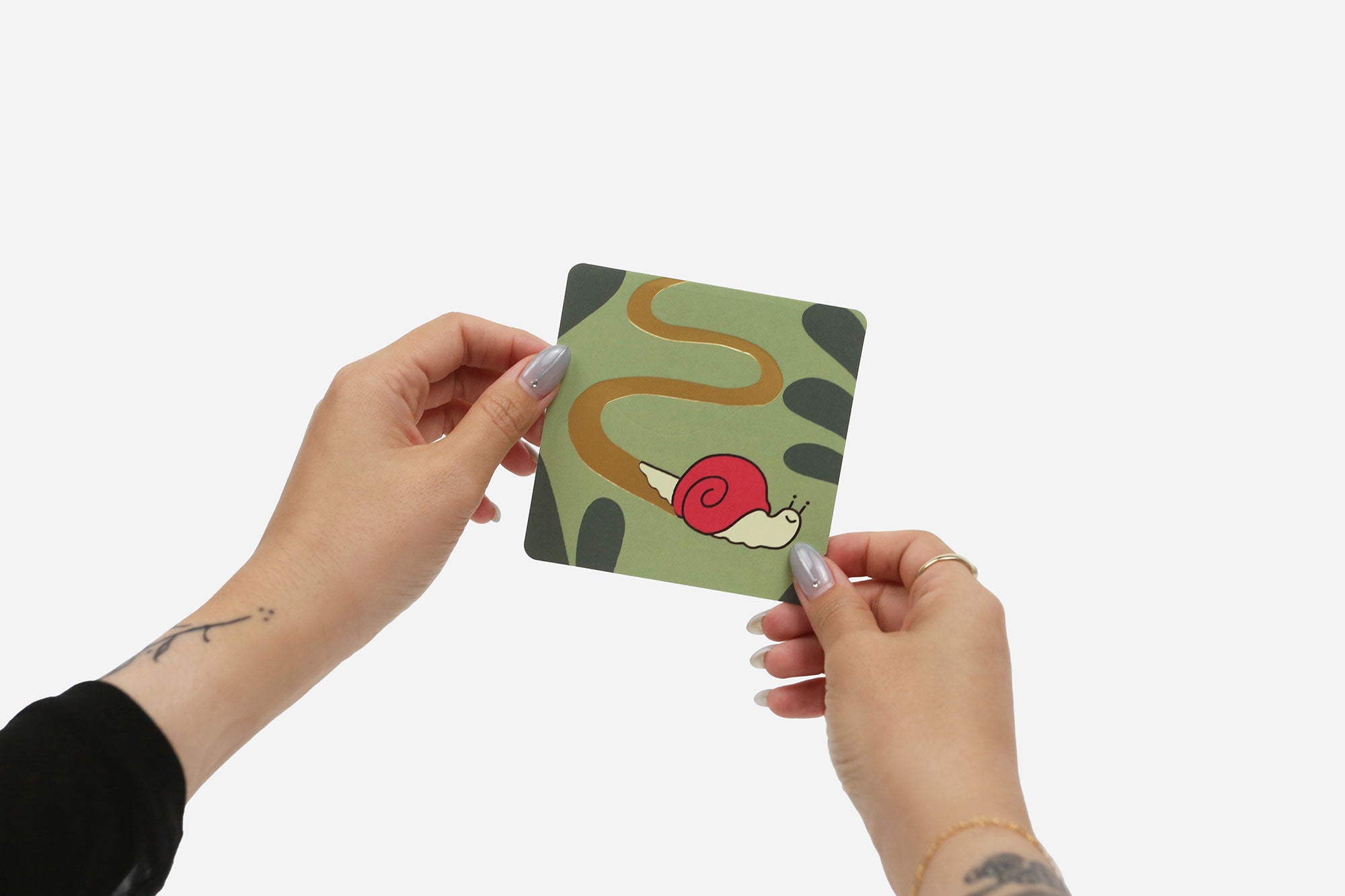 Person holding a card with a snail illustration on a white background