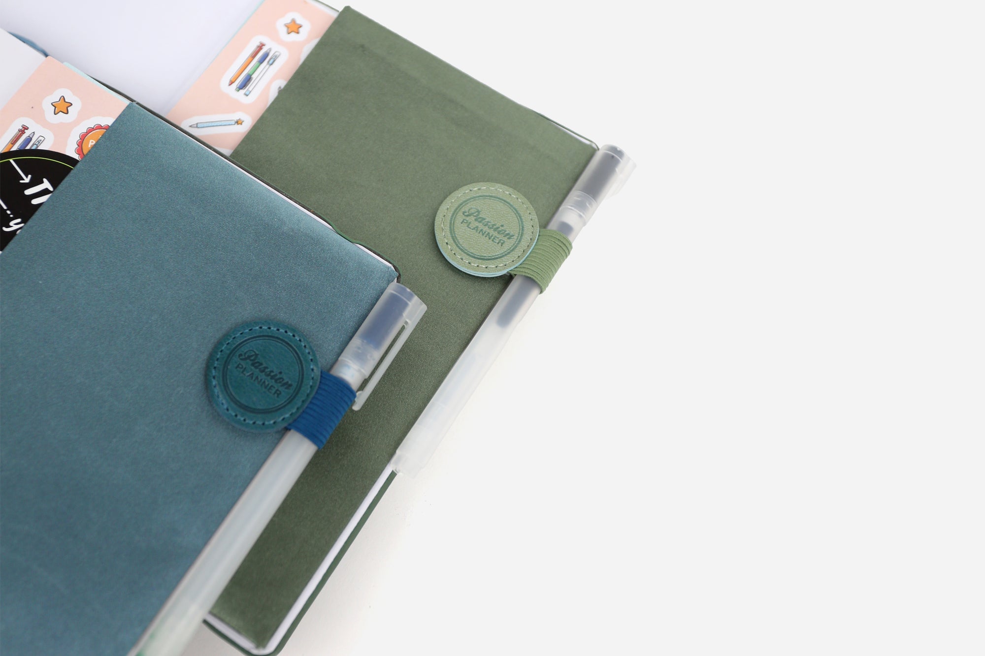 Two planners with pen loops on a white background