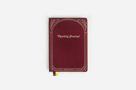 Maroon reading journal with decorative gold foil elements on a white background
