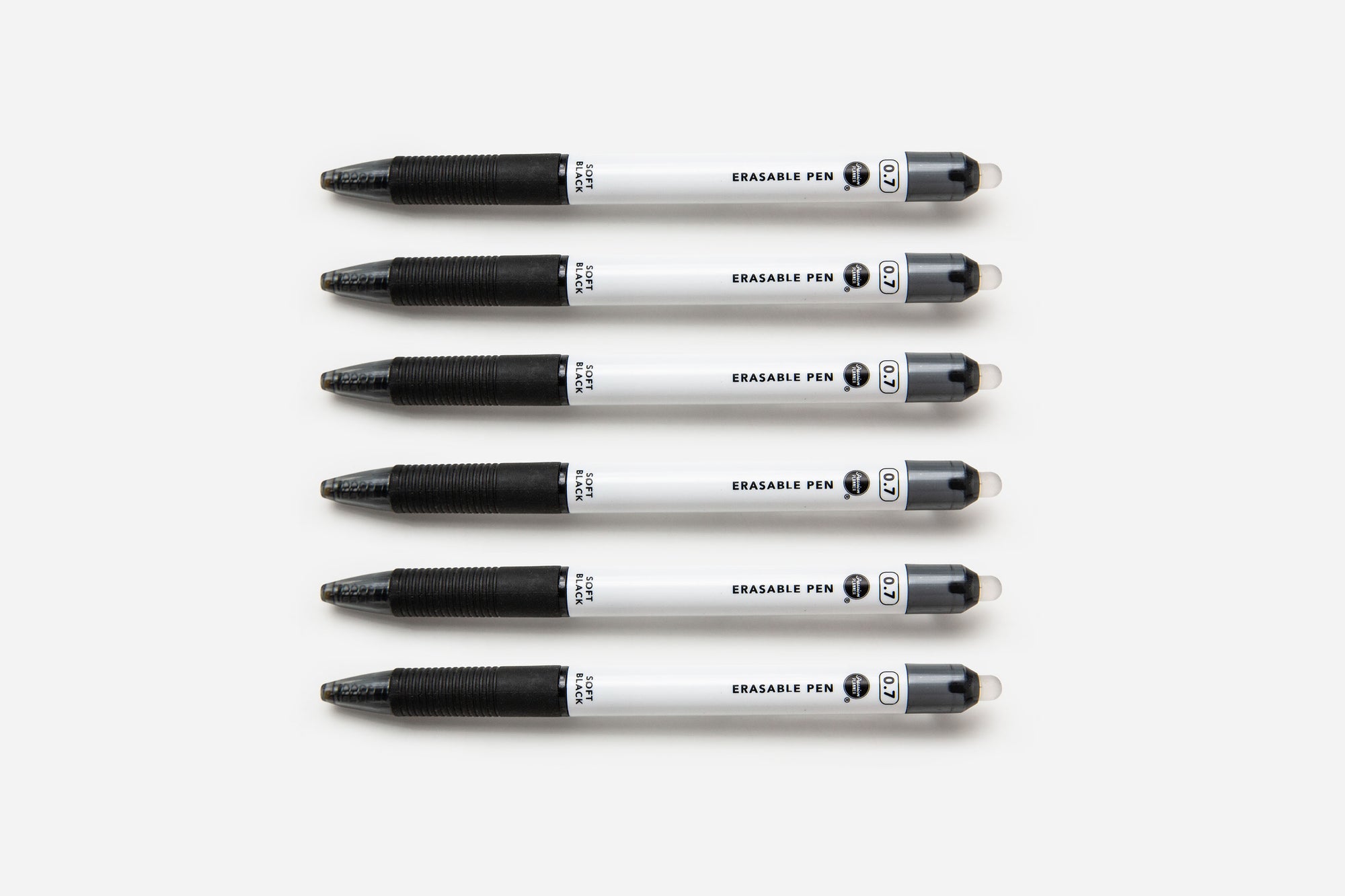 Six soft black pens lined up on a white background.